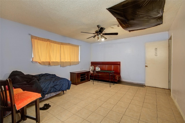 tiled bedroom with ceiling fan and a textured ceiling