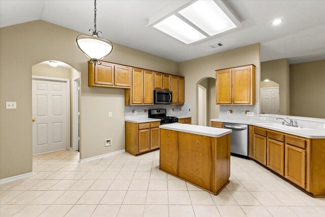 kitchen with light countertops, appliances with stainless steel finishes, hanging light fixtures, and a sink