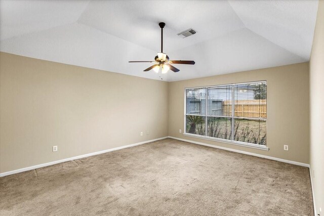 unfurnished room with carpet, visible vents, vaulted ceiling, and baseboards