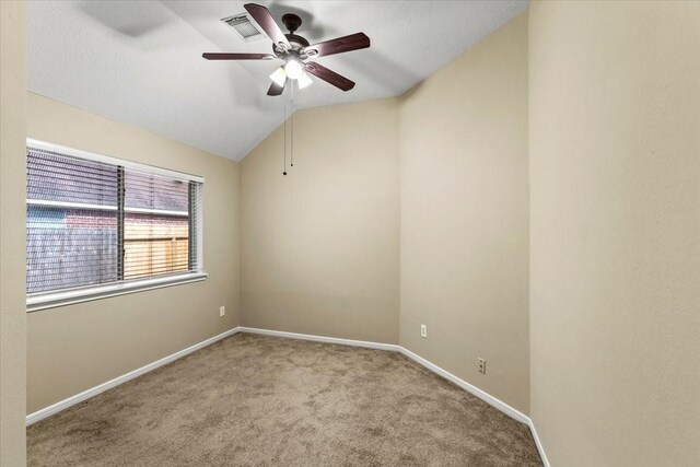 empty room featuring lofted ceiling, light carpet, visible vents, and baseboards