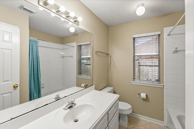 full bath with toilet, plenty of natural light, visible vents, and tile patterned floors