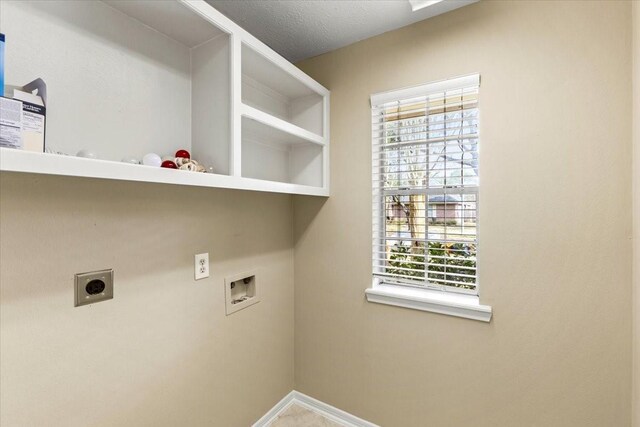 clothes washing area featuring laundry area, baseboards, a textured ceiling, washer hookup, and electric dryer hookup