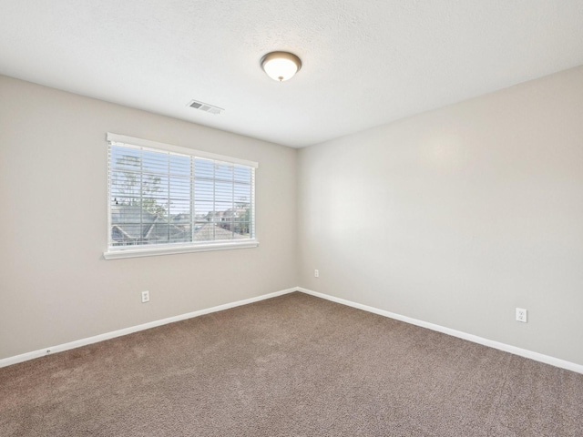 carpeted spare room with a textured ceiling