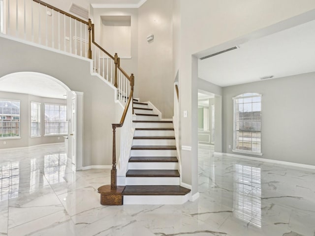 staircase featuring plenty of natural light and a high ceiling