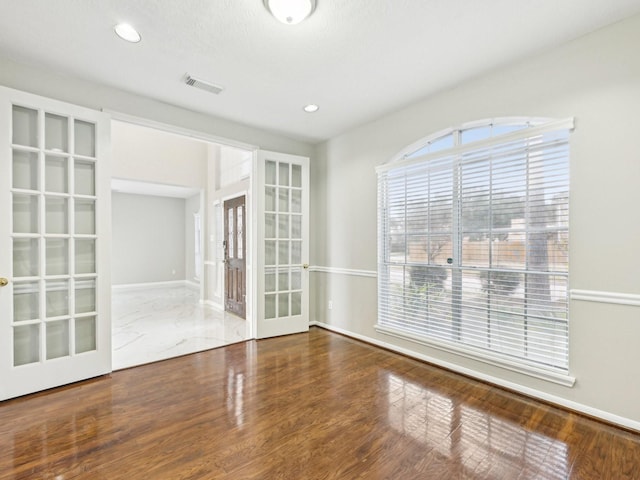 empty room featuring french doors and hardwood / wood-style floors