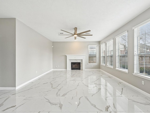 living room featuring a textured ceiling, a high end fireplace, and ceiling fan