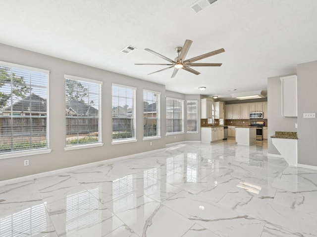 unfurnished living room with a healthy amount of sunlight, a textured ceiling, and ceiling fan