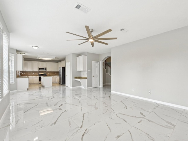 unfurnished living room with ceiling fan and sink