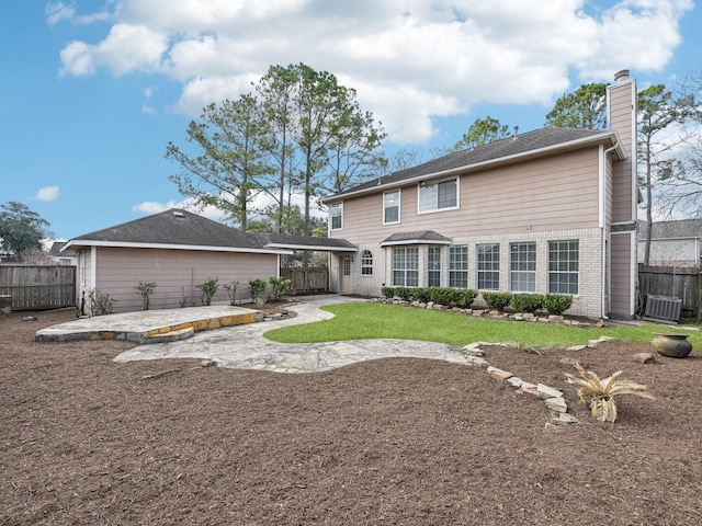 rear view of house featuring central air condition unit, a patio area, and a lawn