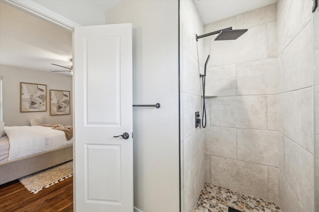 bathroom featuring a tile shower and wood-type flooring