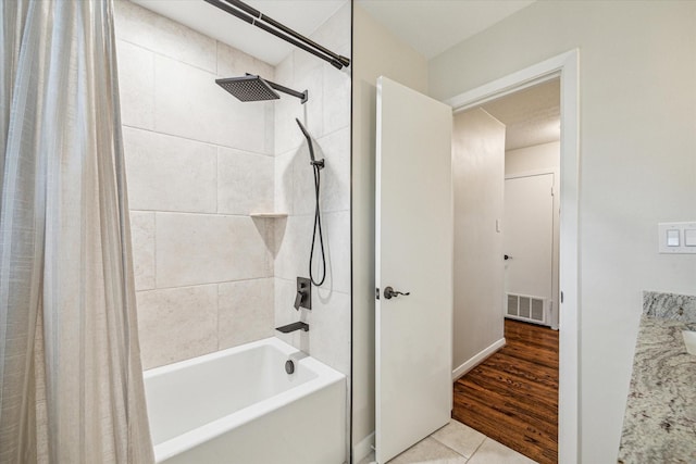 bathroom with shower / bathtub combination with curtain and tile patterned flooring