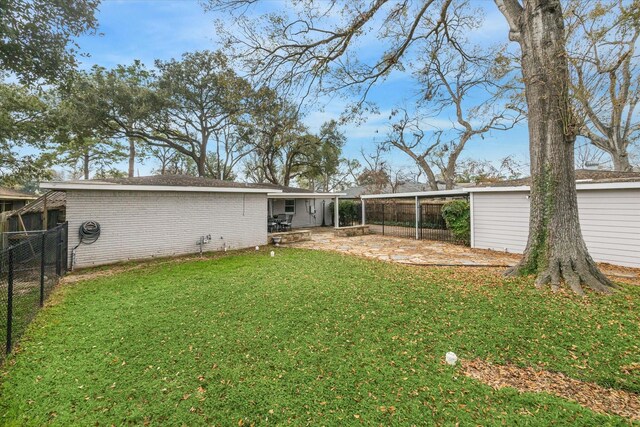 back of house with a patio and a lawn