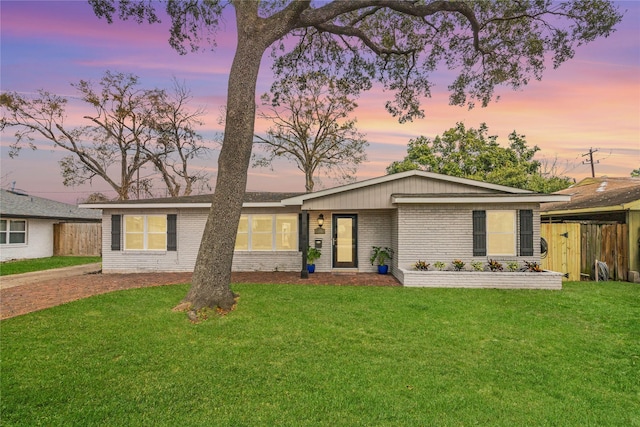 ranch-style home featuring a lawn