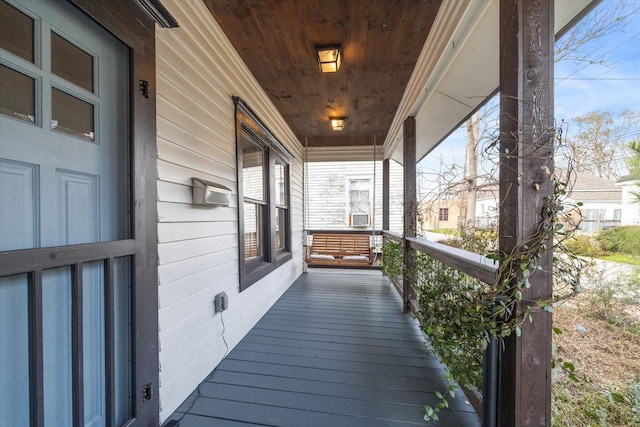 wooden deck featuring cooling unit and covered porch