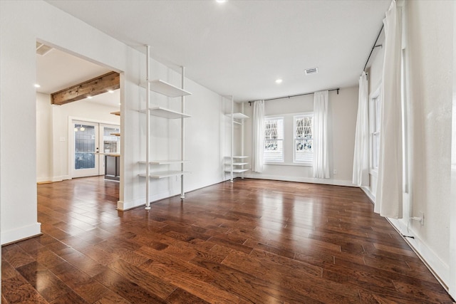 unfurnished room featuring beamed ceiling, dark hardwood / wood-style floors, and french doors