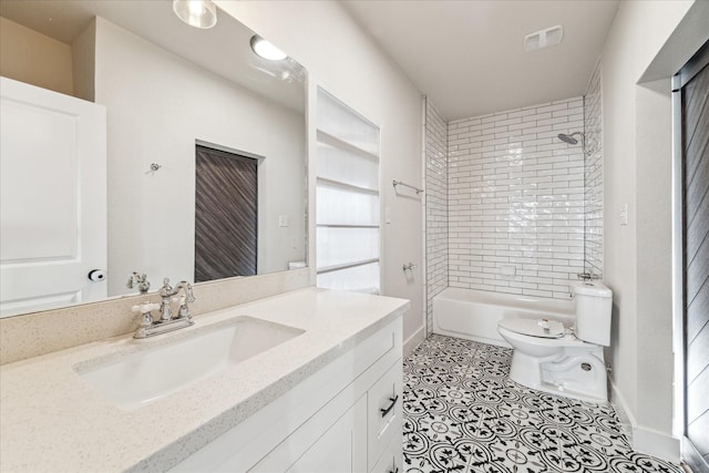 full bathroom with tile patterned flooring, vanity, tiled shower / bath, and toilet