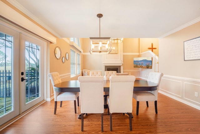 dining room featuring ornamental molding, hardwood / wood-style floors, an inviting chandelier, and french doors