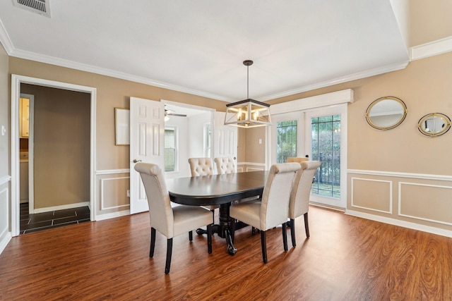 dining space featuring ornamental molding, dark wood-type flooring, an inviting chandelier, and french doors