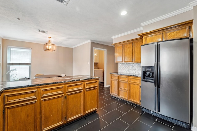 kitchen with stainless steel refrigerator with ice dispenser, ornamental molding, dark tile patterned floors, pendant lighting, and decorative backsplash