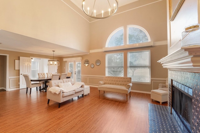 living room with crown molding, a notable chandelier, and hardwood / wood-style flooring