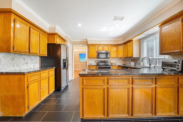 kitchen featuring sink, crown molding, appliances with stainless steel finishes, kitchen peninsula, and dark stone counters