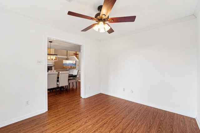 empty room featuring hardwood / wood-style flooring, crown molding, and ceiling fan