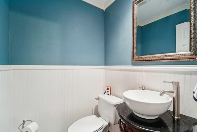 bathroom featuring ornamental molding, toilet, and sink