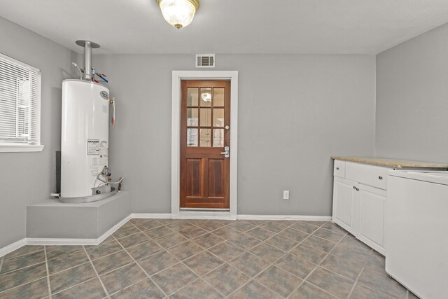 laundry room with tile patterned flooring and gas water heater