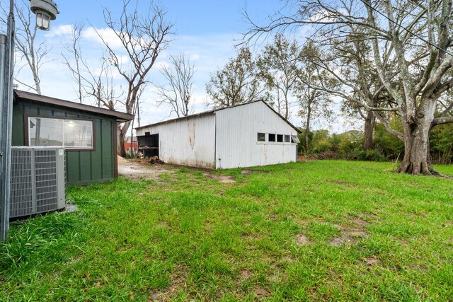 view of yard featuring central AC and an outdoor structure