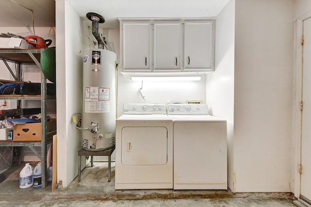 clothes washing area featuring cabinets, gas water heater, and washing machine and dryer