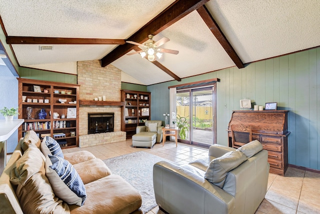 living room featuring ceiling fan, lofted ceiling with beams, a textured ceiling, light tile patterned flooring, and a brick fireplace