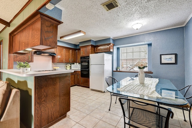 kitchen featuring crown molding, white appliances, a textured ceiling, light tile patterned flooring, and kitchen peninsula