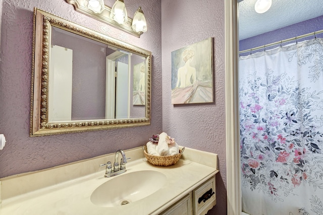 bathroom featuring a shower with curtain, vanity, and a textured ceiling