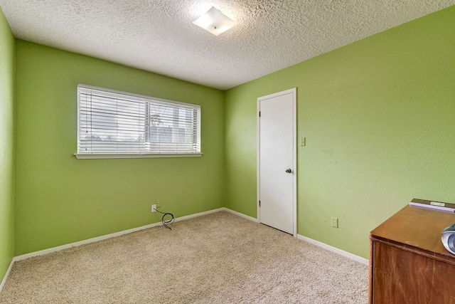 carpeted spare room with a textured ceiling