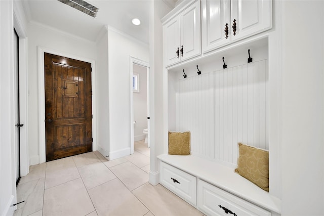 mudroom with ornamental molding and light tile patterned floors