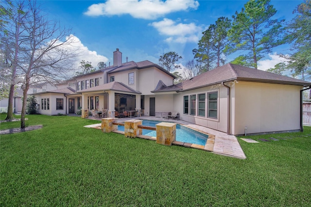 rear view of house with a lawn and a patio area