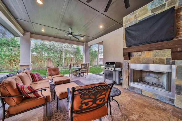 view of patio with ceiling fan, an outdoor living space with a fireplace, and a grill