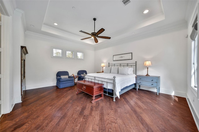 bedroom featuring crown molding, dark wood-type flooring, and a tray ceiling