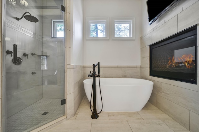 bathroom featuring tile walls, plenty of natural light, tile patterned floors, and separate shower and tub