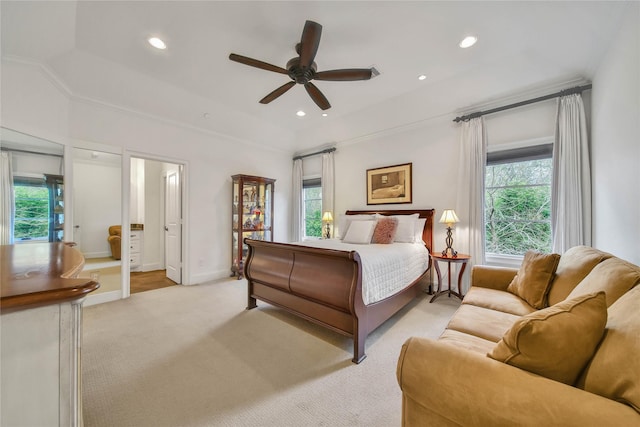 bedroom featuring light carpet, crown molding, ensuite bath, and ceiling fan