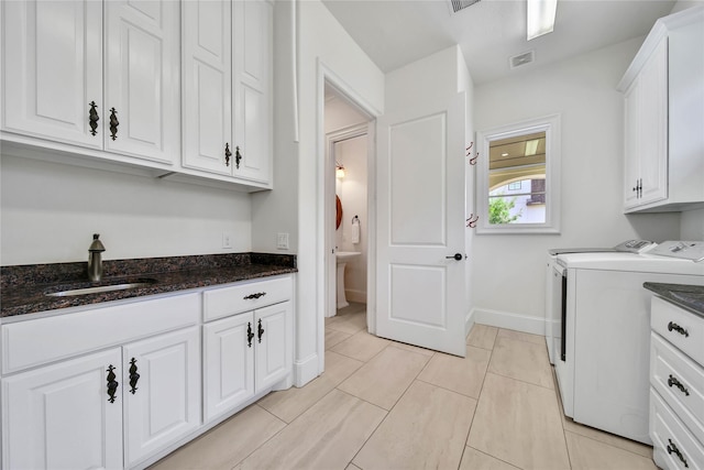 laundry area featuring cabinets, sink, and washer and clothes dryer