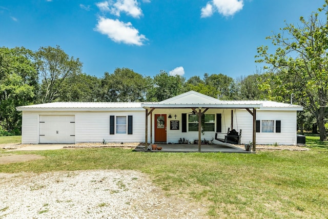 single story home with a garage, central AC, a front yard, and a porch