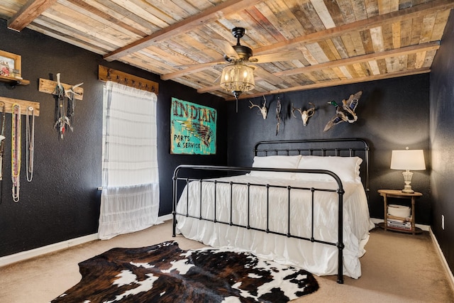 bedroom featuring beamed ceiling, carpet flooring, wooden ceiling, and ceiling fan