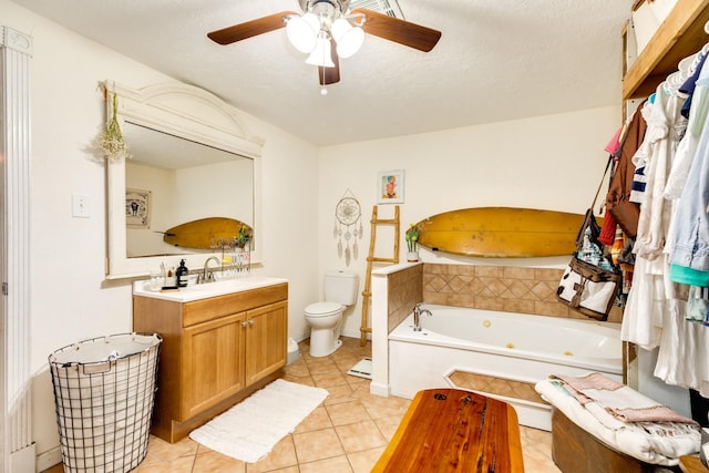 bathroom with tile patterned floors, toilet, a textured ceiling, vanity, and a relaxing tiled tub