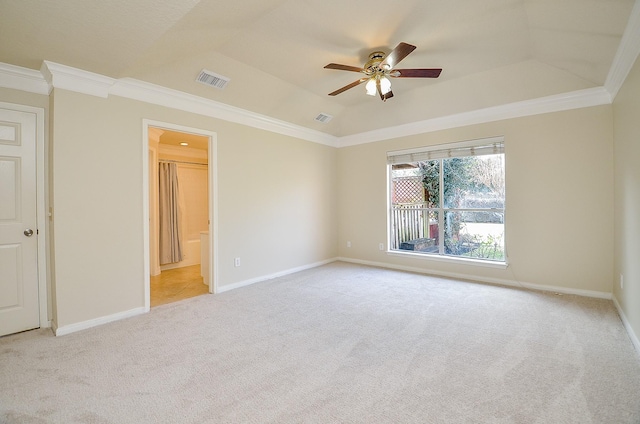 carpeted spare room with a raised ceiling, ornamental molding, and ceiling fan