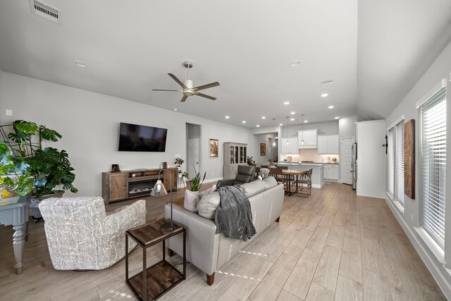 living room with light hardwood / wood-style flooring and ceiling fan