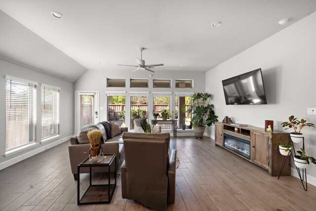 living room featuring hardwood / wood-style floors, vaulted ceiling, and ceiling fan