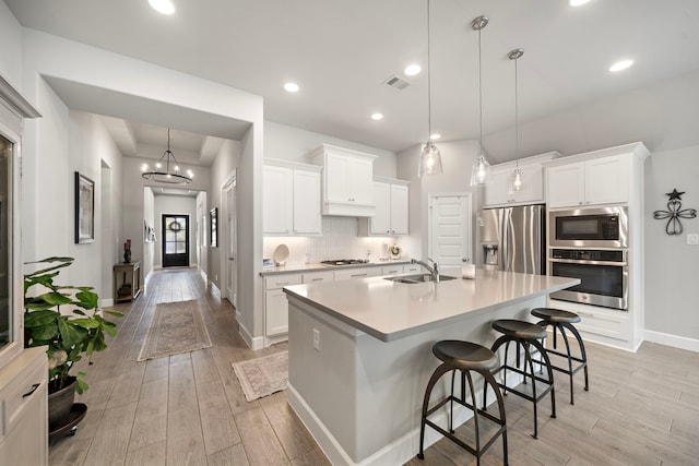 kitchen featuring white cabinetry, appliances with stainless steel finishes, and pendant lighting