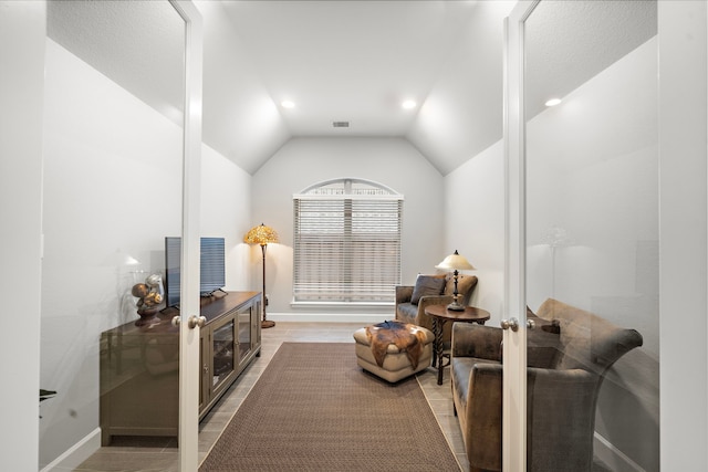 living area with lofted ceiling, hardwood / wood-style floors, and french doors