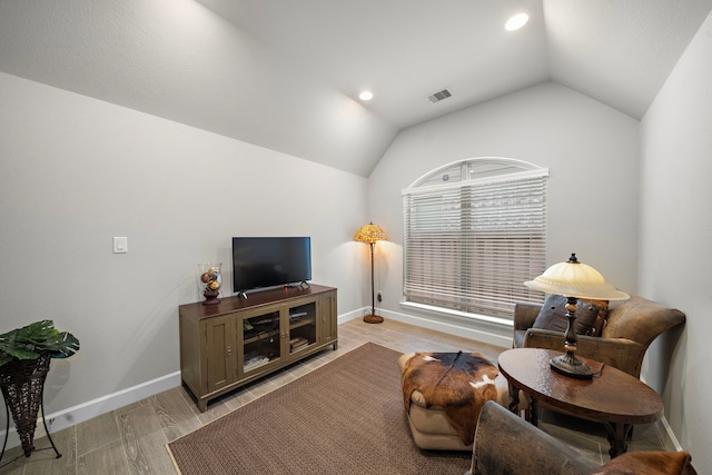 living room with vaulted ceiling and light hardwood / wood-style flooring